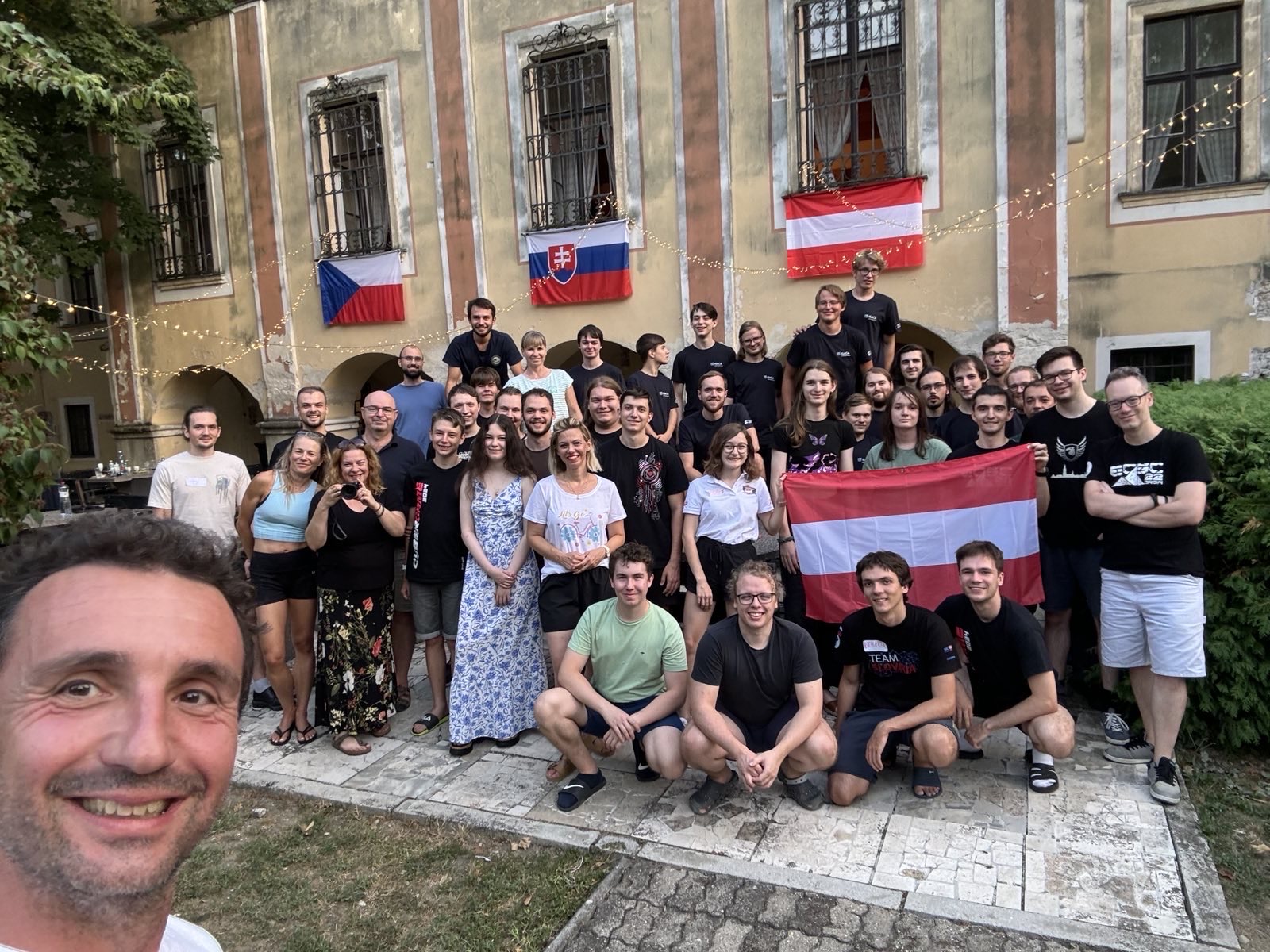 Spoločné selfie tímov na medzinárodnom bootcampe s českou, slovenskou a rakúskou vlajkou