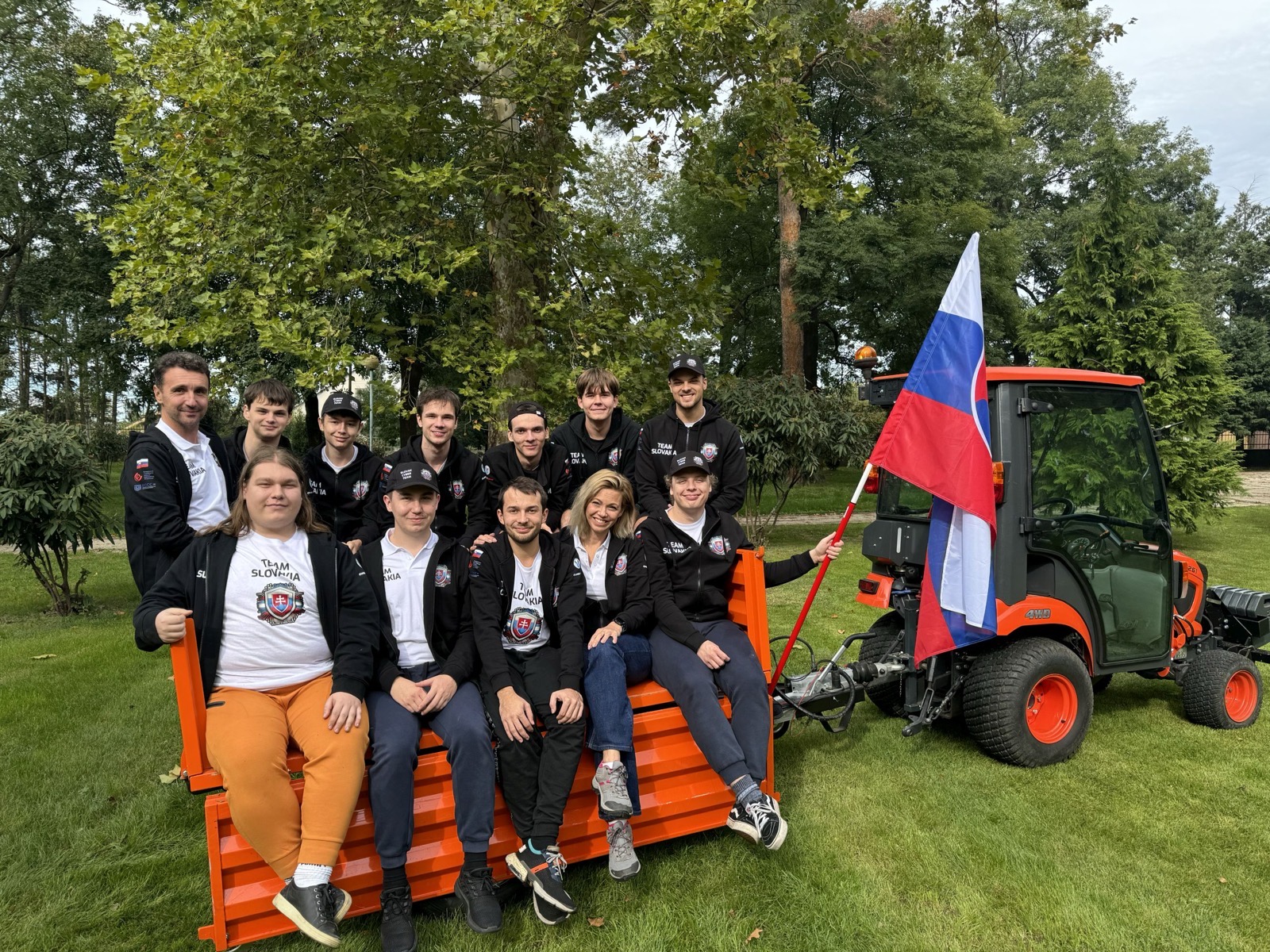 Tím na oranžovom traktorovom vozíku so slovenskou vlajkou